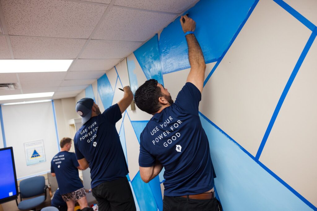 POWER employees volunteer paint a classroom during a volunteer project.