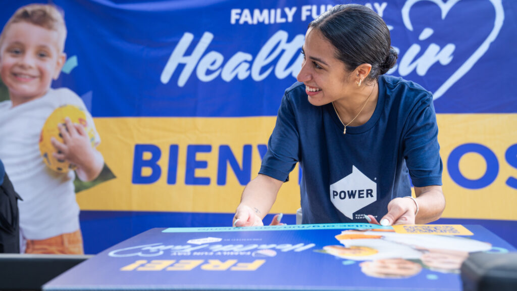 Employee volunteers at the LULAC Health Fair by building signage.