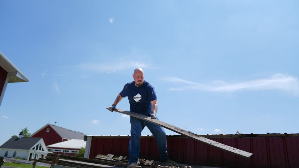 A POWER employee helps to clean up the BraveHearts ranch during a volunteer initiative.