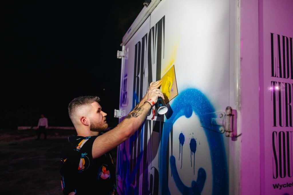 A Quest attendee spray paints on one of the art installations.
