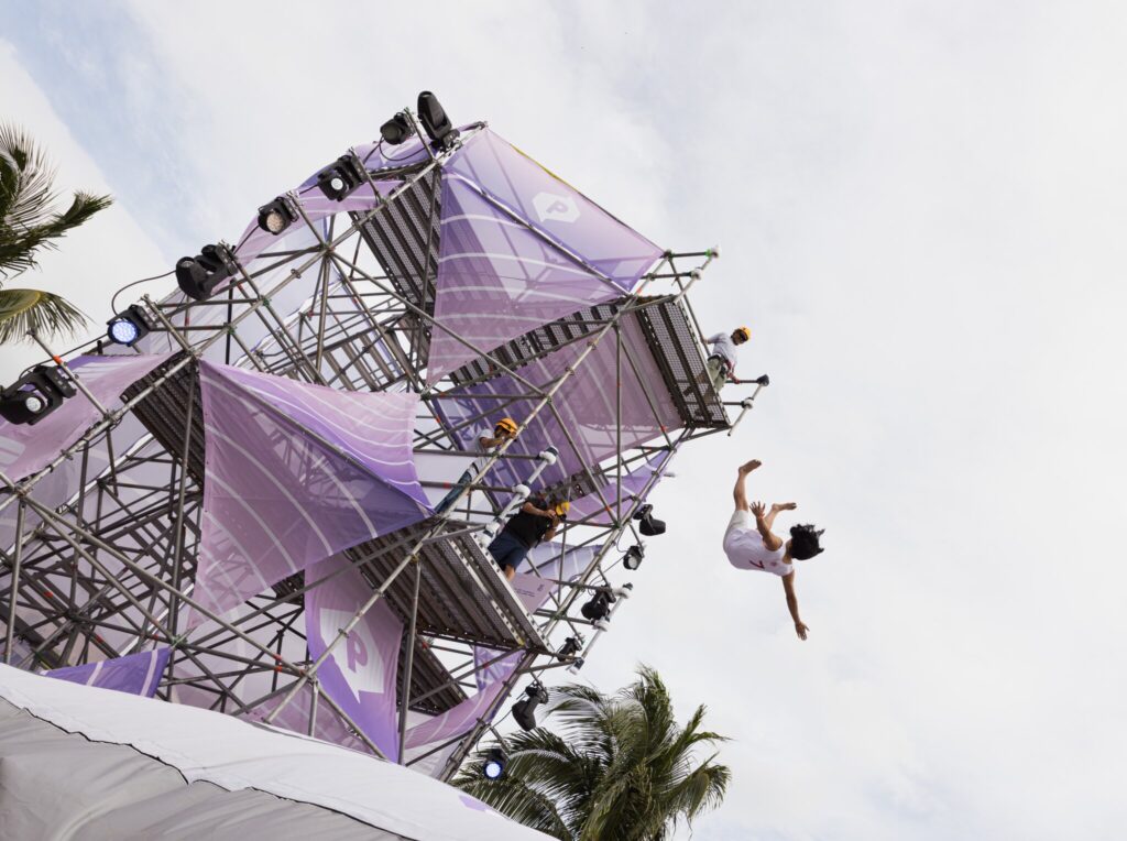 An employee jumps off a three-story Trust Jump installation at Quest.