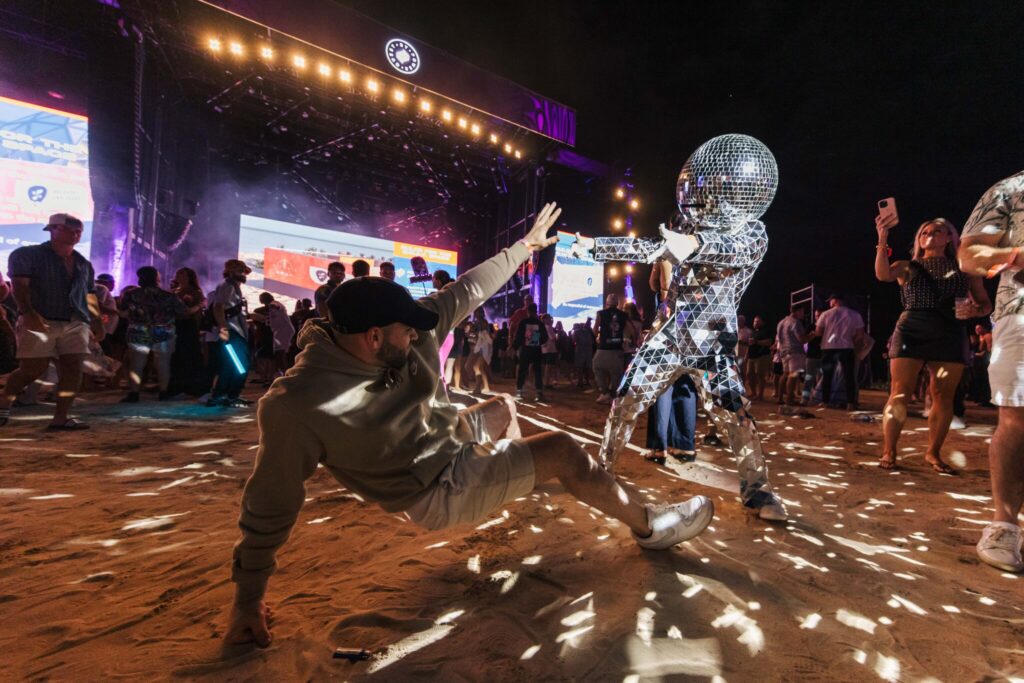 A discoball mascot and Quest attendee dance during the festival.