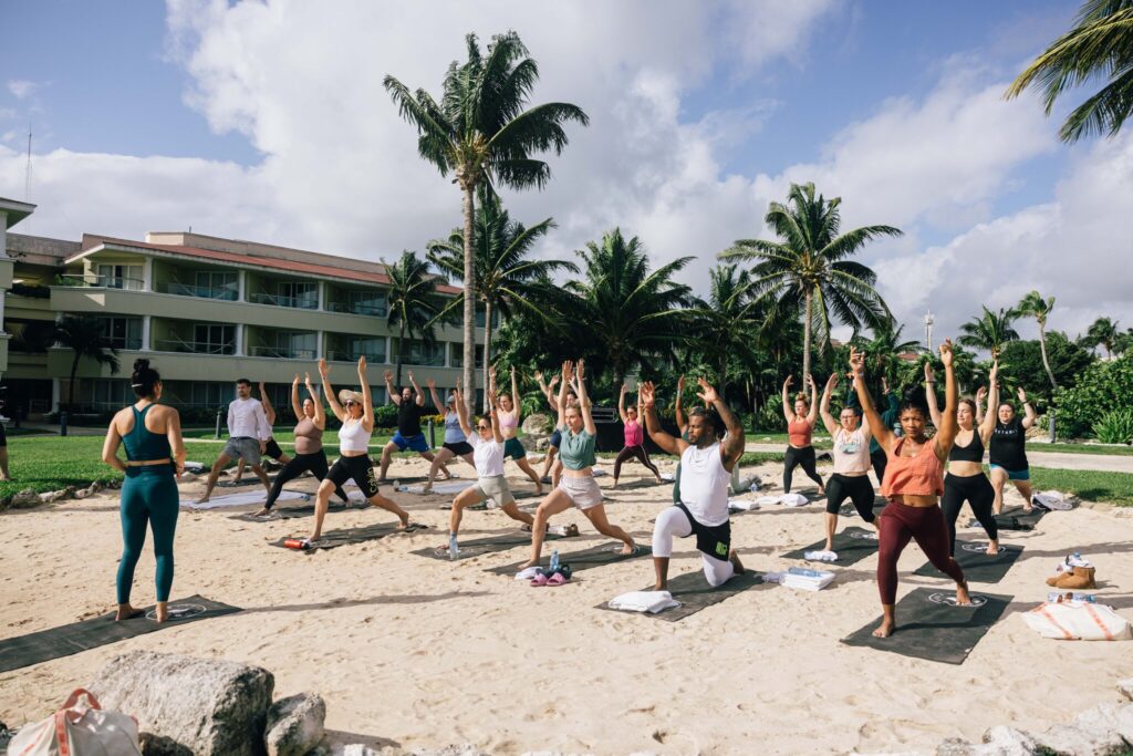 Quest attendees partake in morning yoga on the beach.