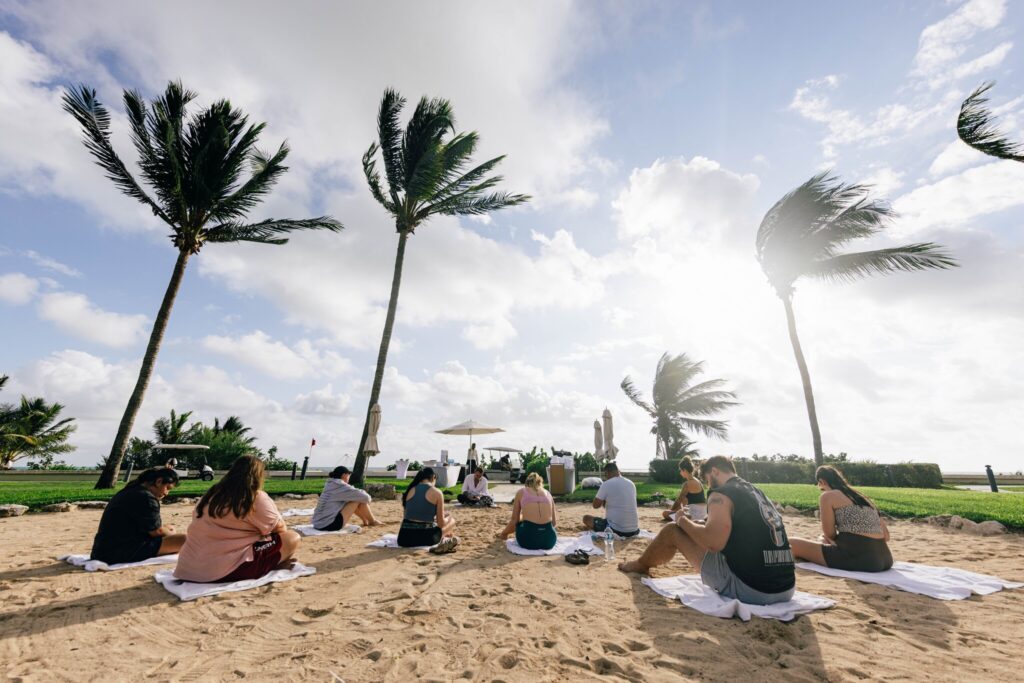 Quest attendees sit on the beach for a guided journaling and meditation session.