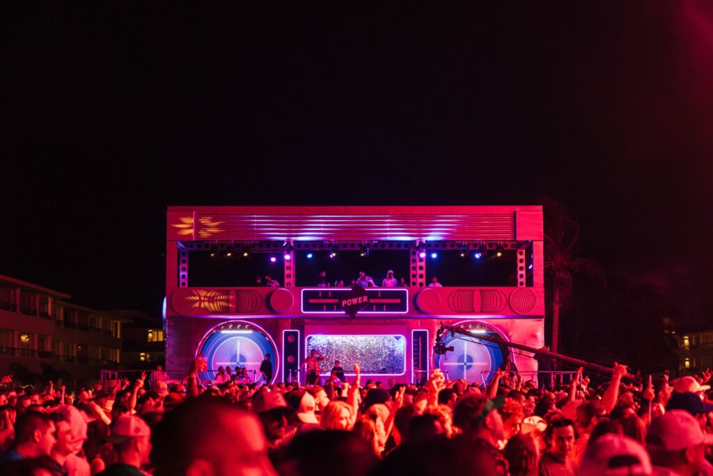 A crowd photo of the Quest music festival with the side viewing stage which is built to look like a giant boombox.