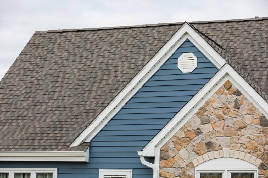 A POWER home featuring blue vinyl siding and a new roof.