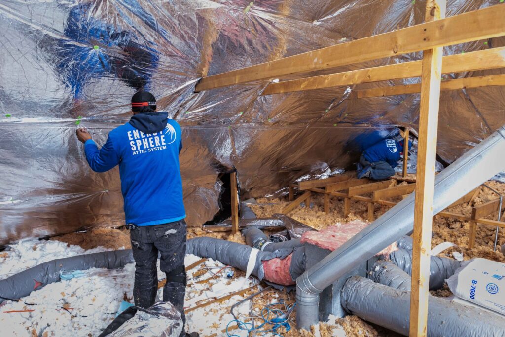 A POWER employee installs attic installation, Energy Sphere.