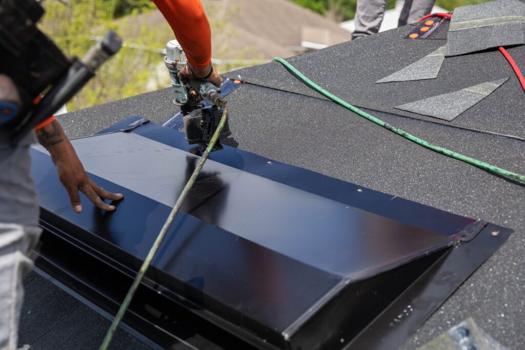 A POWER employee installs ventilation on a new roof.