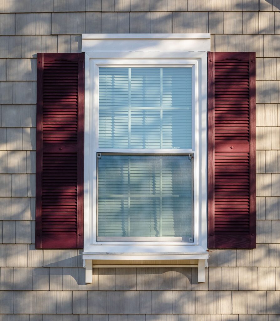A white POWER window with red shutters.