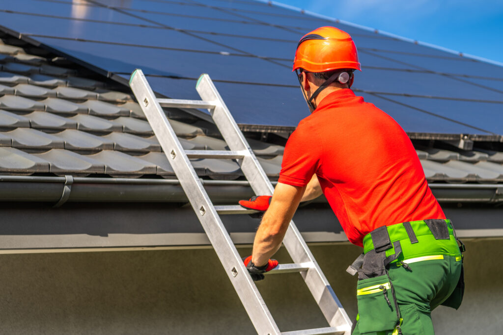 Man climbing ladder outside of a home with three points of contact.