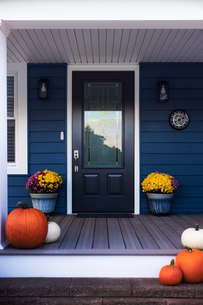 A front porch with pumpkins as decor.