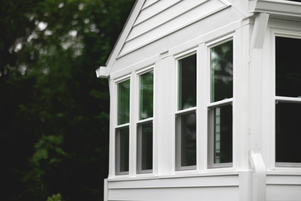 A POWER home with fresh, white siding, gutters, and windows.