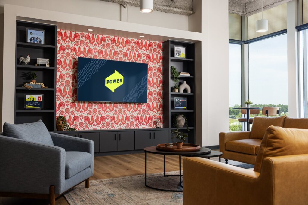 Comm space with a tV and chairs in POWER's Columbus office space.
