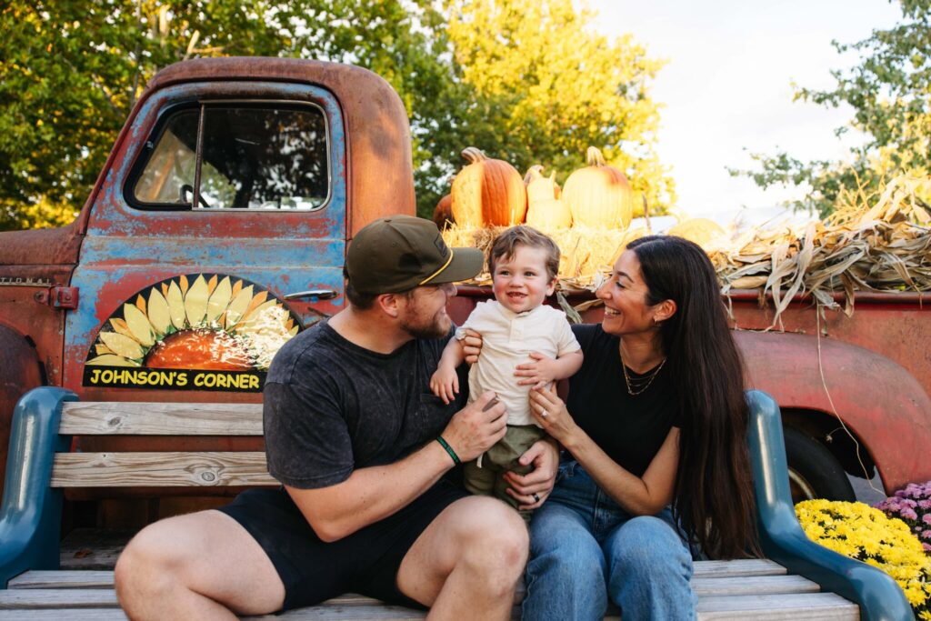POWER parents pose for a photo with their baby during company family event.